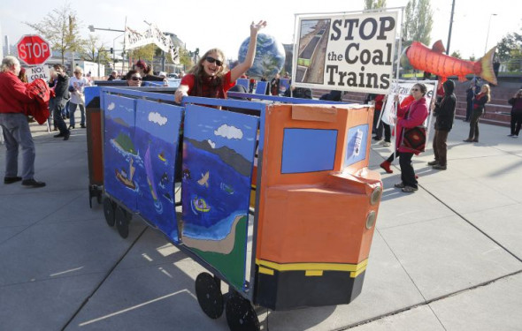 AP A protester rides in a mock coal train as other protesters demonstrate against trains carrying coal for export moving through Washington state on Thursday, Oct. 17, 2013.