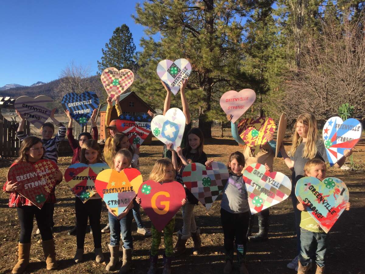 Local 4-H students place colorful hearts on the wreckage in an effort to raise community spirits.